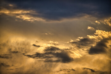 Sun casting long shadows and warm golden hue over clouds