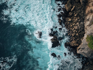 Fototapeta premium Top view of ocean waves crashing into big rocks