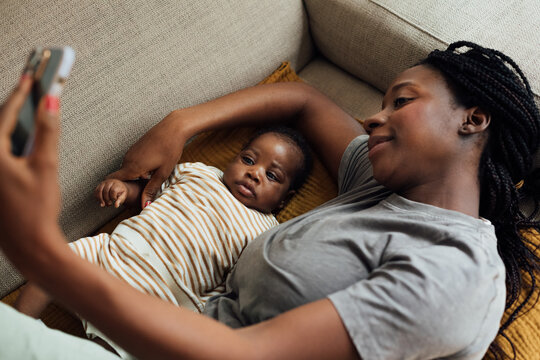 Woman and Her Baby Lying on Couch