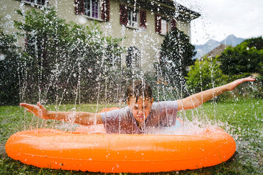 Young Boy Having Fun On Summer Water Slide