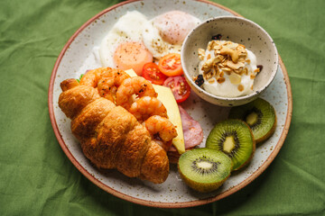 Breakfast sandwiches, croissants, ham, cheese, shrimp, fried eggs and yogurt.