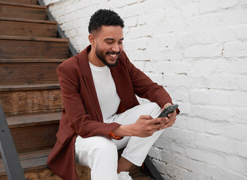Black Man Smiling While Using A Mobile