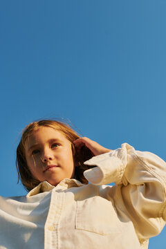 girl straightens her hair in the rays of the setting sun