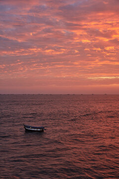 Sunset at Pimentel Beach - Chiclayo, a reddish sky overlooking the sea and a sailing boat
