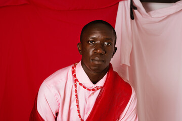 Young black man wearing pink posing at the studio