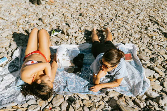 Friends Lounging on Rocky Beach