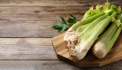 Fresh raw celery roots on wooden table. Space for text