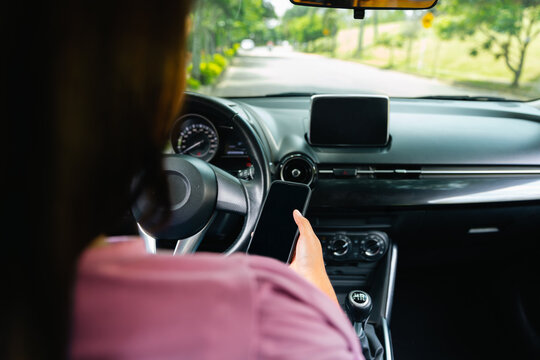 Woman inside her car looking at her phone