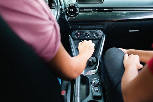 Close-up of a young woman shifting gears in her car