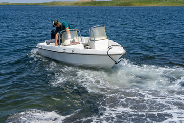 a boat man driving the boat in a lake