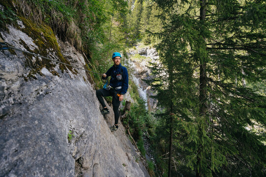 Man Climbing Via Ferrata Rock In Forest