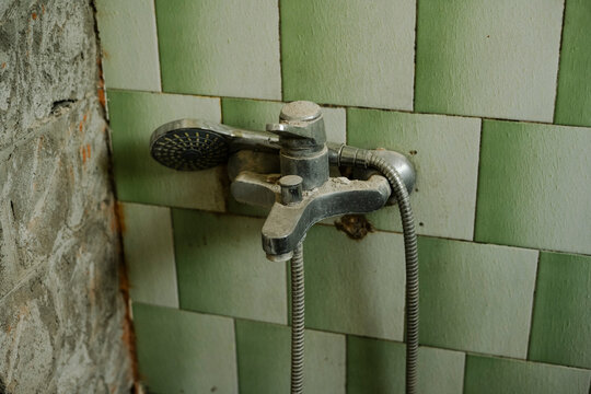 Old shower faucet covered in dust
