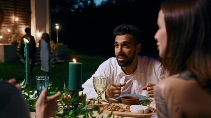 The bride and groom sit down at the festive table to their guests. Outdoor wedding at night