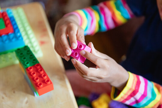 Closeup of a child's hands as she plays with blocks