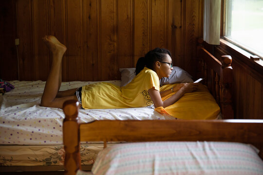 Teenager lying in a quiet bunk while at camp