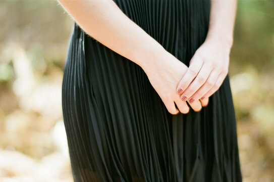 close up of woman in dress holding her hands