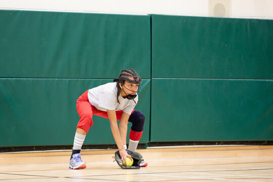 Child practicing proper ready position technique for softball