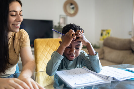 Boy doing homework putting his hands on his head