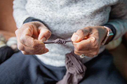 Woman tying a knot i a stocking as part the dryer ball making process