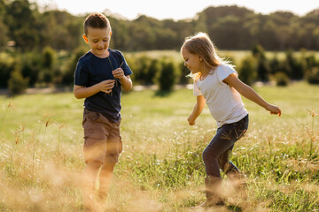 A young boy and girl playing outdoors.