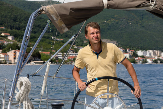 Skipper at the steering wheel of a yacht