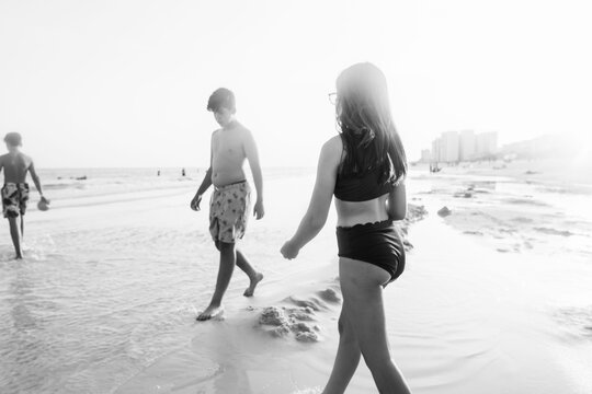 Black and white portrait of three teenage siblings exploring the Gulf.