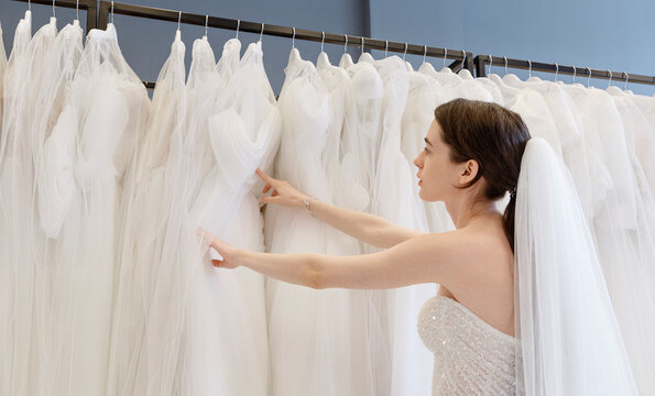Woman choosing weeding dress in shop