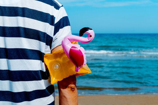 man with a flamingo-shaped armband in his arm