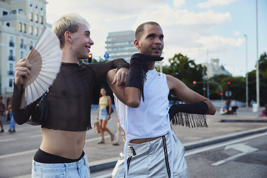 Two queer friends striking poses and voguing on the street