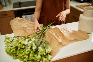 Unwrapped bouquet of flowers on the kitchen counter