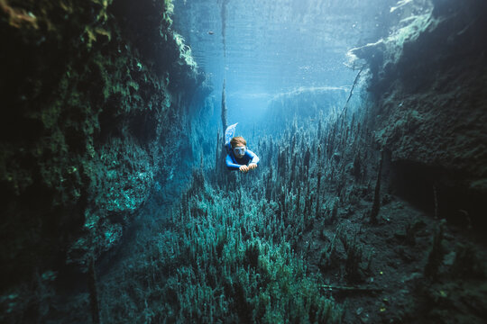 young boy diving through a cave