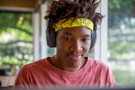 Stylish guy with headband listening to music on headphones