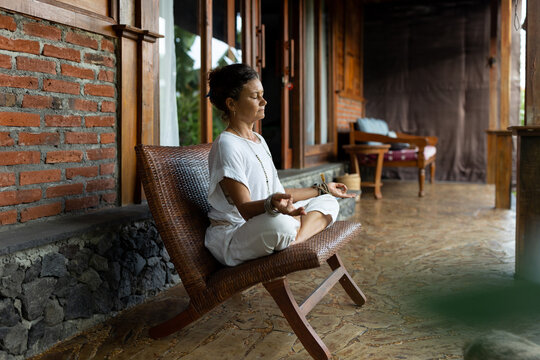 Adult woman meditating on the porch