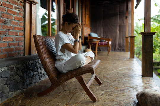 Serene woman meditating at the porch