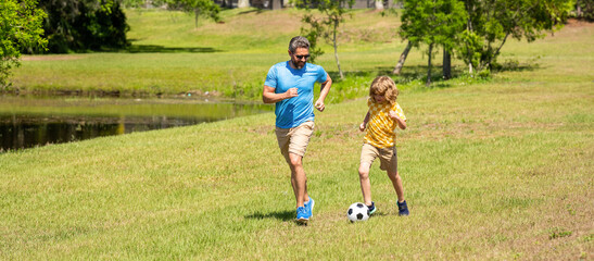 Obraz premium football family team of father and son. Fatherhood in outdoor of daddy and son kid. daddy with son improve fatherhood. Outdoor adventures of daddy and son fatherhood together. happy active family