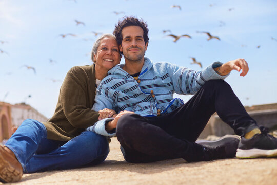 Mother and son creating travel memories under a blue sky.