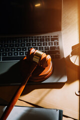 law legal technology concept. judge gavel on computer with scales of justice on desk of lawyer.