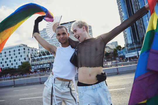 Three queer friends confidently walk down the street during gay pride
