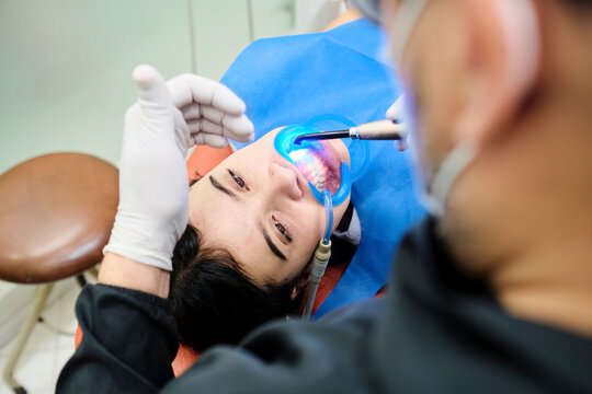 Dentist using a light curator in a patient's mouth