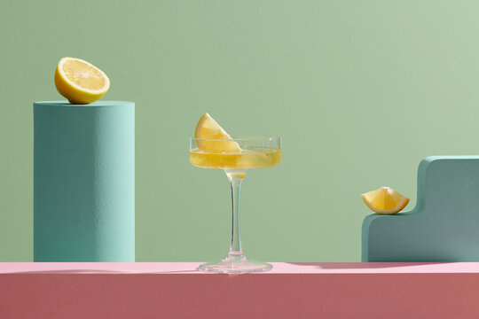 Glass of cocktail with spices citrus fruits on color background