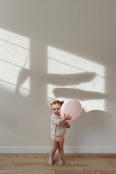 Little baby girl with pink balloon.