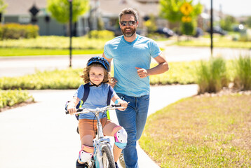 father and son on bicycle at fathers day. active father setting a example for fathers son. fathers parenting with son outdoor. childhood of son supported by fathers care. family fun day