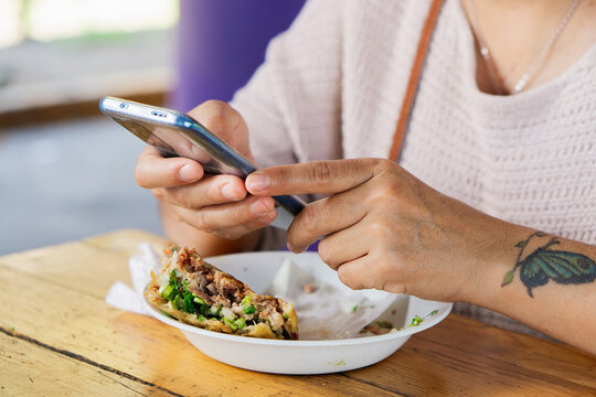 Unrecognizable person eating in the street.