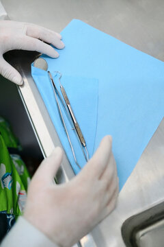 Dentist wrapping dental instruments in a paper towel