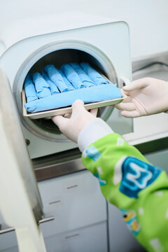 Assistant sterilizing dental instruments
