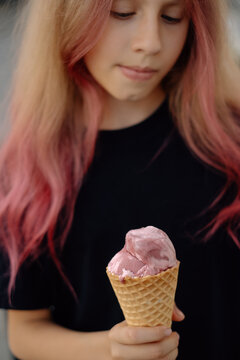 Teenage girl with pink hair holding ice cream