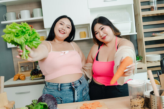 Happy Asia plus size woman smiling holding grocery shopping bag with vegetables and fruit.