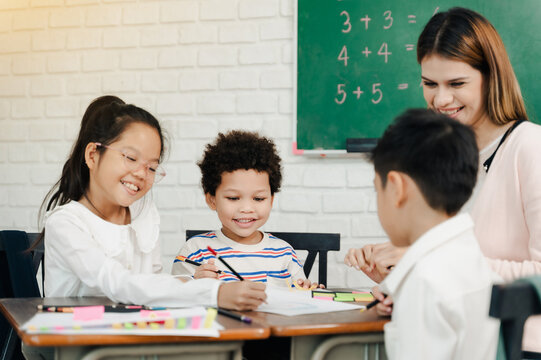 Asian students and woman teacher teach and learning at class room in school with green chalkboard background.