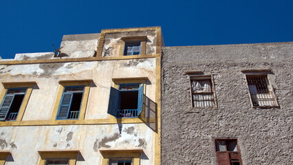 Old building with yellow trim and blue shutters above the market in Essaouira, Morocco