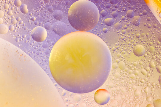 Purple And Yellow Oil Drops On Water Surface  